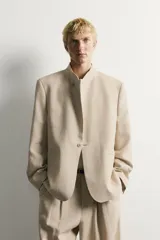Blazer de corte relaxed fit confeccionado en tejido de lino y algodón de origen italiano. Presenta cuello mao, cierre cruzado con botones, bolsillos de vivo en la cadera y manga larga.
