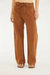 Pantalón de jean de corte recto y tiro medio color marrón, con bolsillos funcionales, lazo ajustable en la cintura confeccionado en la misma tela y detalle de acabado desflecado en el borde superior.