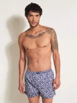 Bóxer de algodón blanco con estampado de flores pequeñas color celeste, con cintura elástica y logo de la marca en el centro.