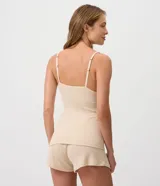 Pijama short doll de dos piezas en color beige, confeccionado en ribana acanalada de viscosa y elastano. Incluye una musculosa con breteles finos regulables y un short corto de cintura elastizada.