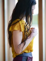 Blusa color naranja de gasa pintada con cuello asimétrico y mangas cortas.