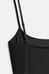 Vestido corto negro de corte ajustado, con escote recto y tirantes finos ajustables.