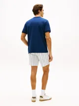 Remera de corte slim color azul marino, con cuello redondo clásico, manga corta y detalle de doble raya en los puños. Presenta el icónico logo bordado de la bandera de Tommy Hilfiger en el pecho.