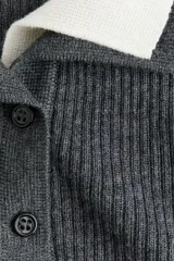 Top de manga larga en tejido de punto acanalado, de corte ajustado, con cuello elevado y tapeta de botones frontal, presentando un diseño con forro interior en contraste.