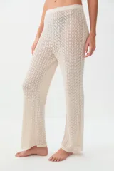 Pantalon de tejido de punto calado en color beige, con corte recto y tiro medio.
