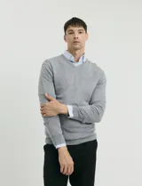 Sweater de punto con escote en V y manga larga, con puños y ruedo acanalados.