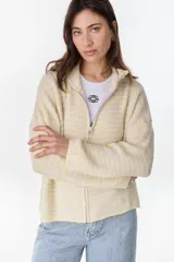 Campera de punto a rayas horizontales en tonos amarillo pastel y lila, con cuello alto, cierre frontal completo y mangas largas con bordado distintivo en la manga.