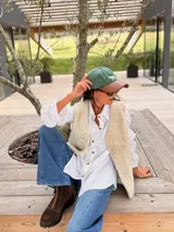 Gorra tipo polo con cuerpo de tela verde y visera de cuero marrón, con un caballo bordado en el frente.