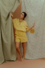Campera tipo bomber de lino color amarillo, con cierre frontal metálico y mangas largas con puños elásticos.