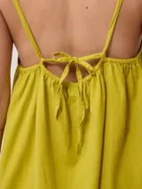 Vestido corto fucsia de algodón y lino, con breteles finos y escote recto con lazo ajustable.