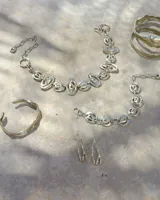 Pulsera de diseño artesanal elaborada eslabón por eslabón a mano, con eslabones circulares texturados de metal dorado y cadena regulable.