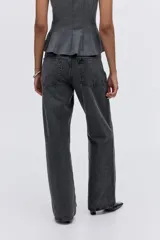 Jean de cinco bolsillos en denim de algodón rígido color gris oscuro, con piernas amplias y corte holgado. Tiene cintura de tiro alto con cierre y botón.