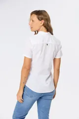 Camisa de lino de manga corta con cuello camisero, cierre frontal de medio botón con botones metálicos personalizados y dos bolsillos en el pecho.
