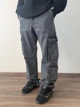Jean cargo de corte baggy en color gris lavado, con múltiples bolsillos laterales y cierre frontal.