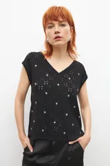 Blusa negra con bordado broderie de flores, escote en V y mangas cortas.