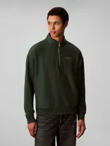 Buzo Calvin Klein de felpa color verde oscuro, con cuello alto, cierre frontal parcial de un cuarto y manga larga. Presenta el logo de la marca bordado en el pecho.