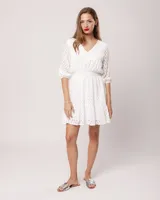 Vestido corto negro de broderie de algodón, con escote en V, mangas tres cuartos, cintura elastizada, falda corte A con volado y forro interior.