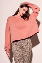 Sweater oversize de algodón lavado color rosa viejo, con cuello redondo y mangas largas con puños acanalados.