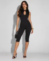 Mono negro al cuerpo, de largo capri y diseño sin mangas, con cuello alto y abertura tipo gota en el escote.