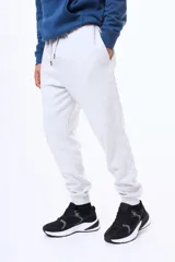 Pantalón de felpa con cintura elástica ajustable mediante cordón, bolsillos laterales y puños acanalados en los tobillos.