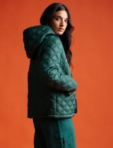 Campera capitoneada azul marino con capucha desmontable, cierre metálico central, bolsillos delanteros y avíos metálicos con logo de la marca Michael Kors.