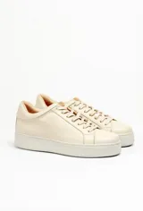 Zapatillas color beige claro, con capellada de cuero suave y acolchado, forro y plantilla de cuero vacuno, y suela de EVA. Tienen una plataforma de 3.8 cm en la parte trasera y 3.2 cm en la delantera.