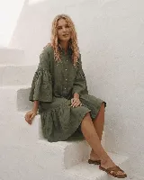 Vestido corto de lino color celeste, con cuello mao, cierre frontal abotonado con botones de nácar, mangas tres cuartos acampanadas con volados y falda con volante en el dobladillo.
