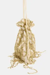 Bolso tipo saca de color crudo con cuerpo cubierto de lentejuelas doradas formando un patrón de red con flecos colgantes. Posee doble asa de hombro y cierre mediante fruncido.