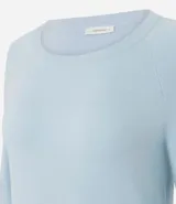 Suéter de punto color marrón chocolate, con cuello redondo y mangas largas con puños acanalados. Presenta un diseño básico y versátil de corte recto.