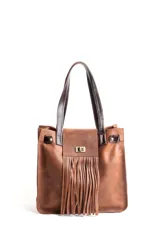 Cartera tipo tote de cuero color marrón con textura granulada. Presenta un diseño con flecos frontales, cierre de broche metálico y correas de hombro en cuero oscuro. Incluye detalles de herrajes dorados.