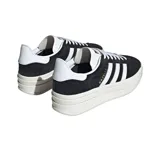Championes adidas modelo Gazelle Bold, de diseño clásico con plataforma triple. Confeccionados en gamuza negra con las tres tiras laterales y refuerzo en el talón en color blanco. Incluye el nombre del modelo en letras doradas en el lateral y suela de plataforma de goma en tono crema.