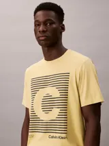 Remera Calvin Klein de manga corta y cuello redondo, color amarillo, con estampado gráfico frontal de líneas horizontales y la letra C en el centro.