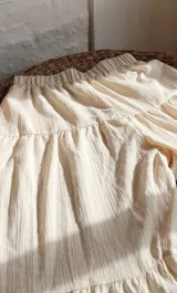 Pantalón beige de corte palazzo, con cintura elástica y diseño escalonado.