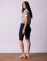 Bermuda blanca de gabardina elastizada marca Zac & Rachel. Tiene pretina ancha elastizada, bolsillos delanteros y traseros, y ruedo con dobladillo.