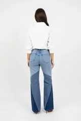 Pantalón de jean con diseño de paneles en tres tonos de azul, corte ancho y tiro alto con cierre de botones a la vista.