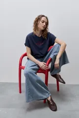 Remera blanca de silueta amplia y calce relajado, confeccionada en tela suave y liviana, con cuello redondo, mangas cortas con vuelta y hombros caídos. Cuenta con un delicado bordado frontal en color azul con la inscripción "LE SOLEIL TOUTE L'ANNÉE sur la Côte d'Azur".