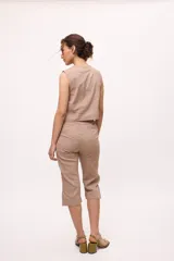 Pantalón capri color beige, de tiro alto y corte recto. Confeccionado en lino y algodón.