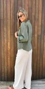 Blazer verde militar de lino con corte entallado, solapas clásicas, cierre con dos botones, bolsillos delanteros y mangas 3/4 con detalle de botón.