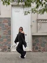 Pantalón de lanilla color negro, de corte recto y tiro alto, con diseño holgado y fluido.