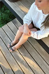 Sandalias bajas de cuero con dos tiras, una de cuero liso color gris y otra con estampado animal print.