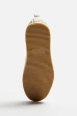 Alpargata color beige de tejido de punto transpirable, con tirador trasero y suela recubierta de yute.