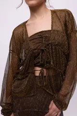 Camisa de chiffon negra con brillos plateados, escote en V, mangas largas abullonadas y jaretas para fruncir y entallar.