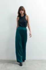 Pantalón largo de vestir color verde esmeralda, de tela satinada y corte palazzo.