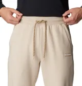 Pantalón de jogging Columbia modelo Marble Canyon, color beige, con cintura elástica ajustable con cordón, bolsillos laterales y bolsillo trasero. Presenta puños acanalados en los tobillos y logo de la marca bordado en la parte frontal.