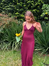Vestido largo azul con escote en V y top de lentejuelas, tirantes finos cruzados en la espalda, recortes cut-out laterales en la cintura y falda larga con tajo y volados.