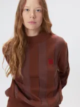 Sweater de punto con cuello polera, diseño a rayas verticales en tonos azules y logo bordado en color amarillo en el pecho. Presenta puños y ruedo ajustados.