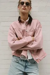 Cazadora de denim efecto lavado color rosado, con cuello solapa de pana marrón, cierre frontal con botones metálicos y bolsillos delanteros de plastrón.