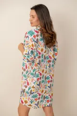 Vestido corto camisero con estampado de rayas multicolores, cuello camisero, mangas tres cuartos y cierre frontal de botones.