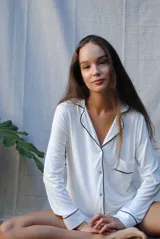 Camisa celeste con cuello clásico, cierre frontal con botones, manga larga con puños abotonados y bolsillo de parche en el pecho.