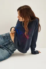 Buzo de cuello redondo y manga larga, en color azul oscuro con efecto lavado. Presenta un estampado frontal con la palabra 'HAPPY' repetida en un degradado de colores vibrantes.